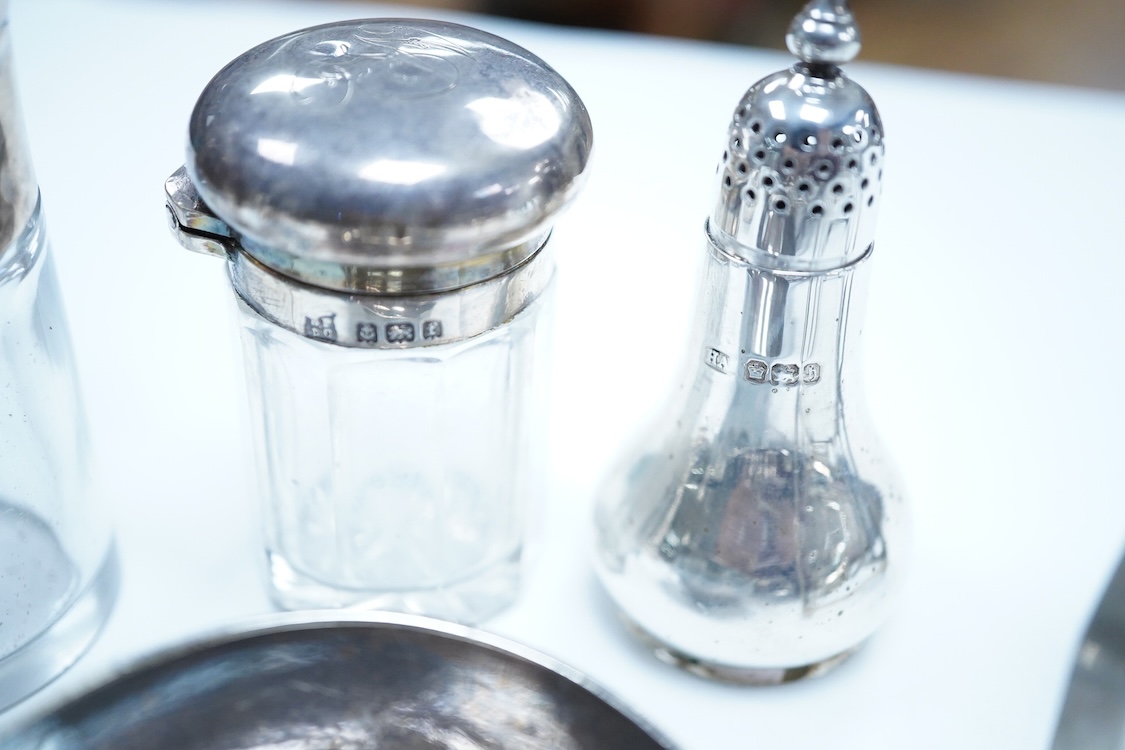 A group of assorted silver, to include a pair of modern five bar toast racks, a George V card case, a sterling vesta case, four assorted condiments, two mounted toilet bottles, mounted timepiece, a modern wooden handled